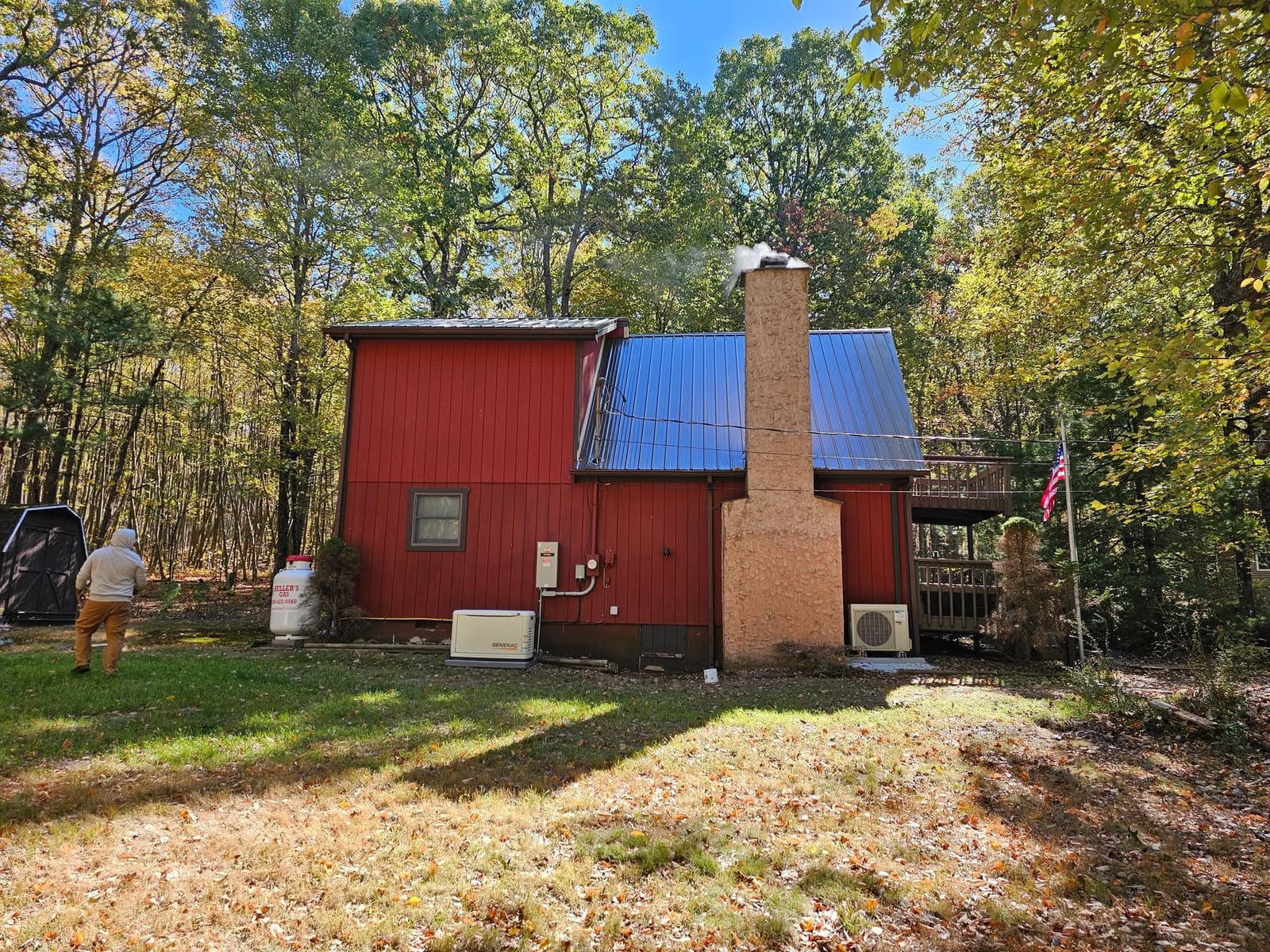 Red lake house with a brand new black standing-seam metal roof